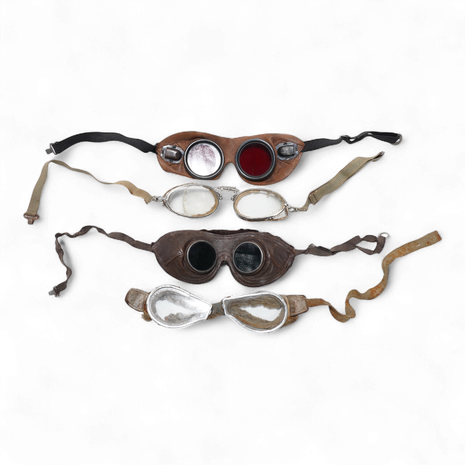 A pair of early aviation aluminium framed flying goggles, a pair of leather and felt lined goggles with green tinted lenses, a pair of French ? aviator flying goggles and a pair of WW2 First Pattern RAF Night Simulation